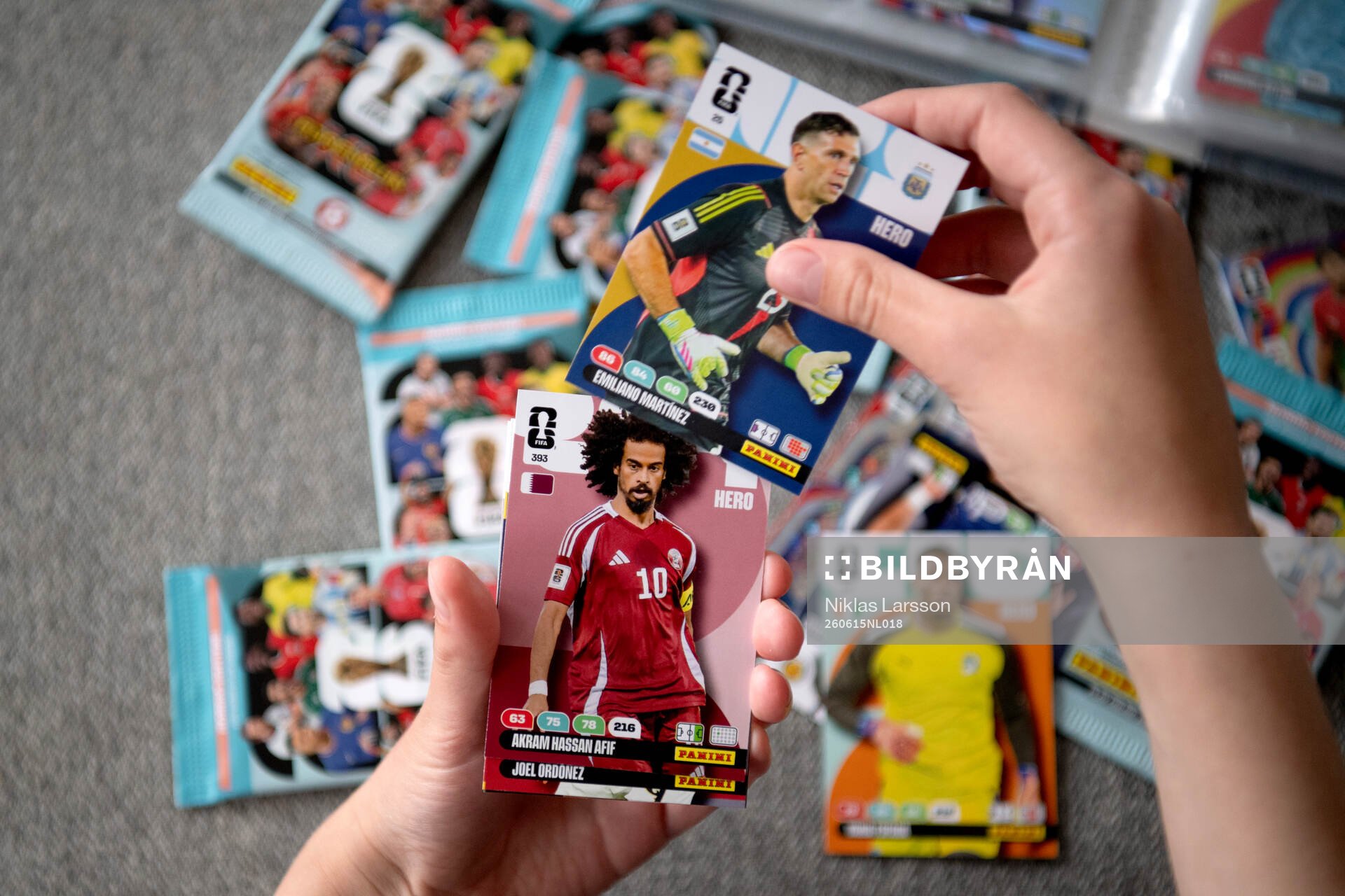 Två händer som håller i samlarbilder på fotbollsspelare