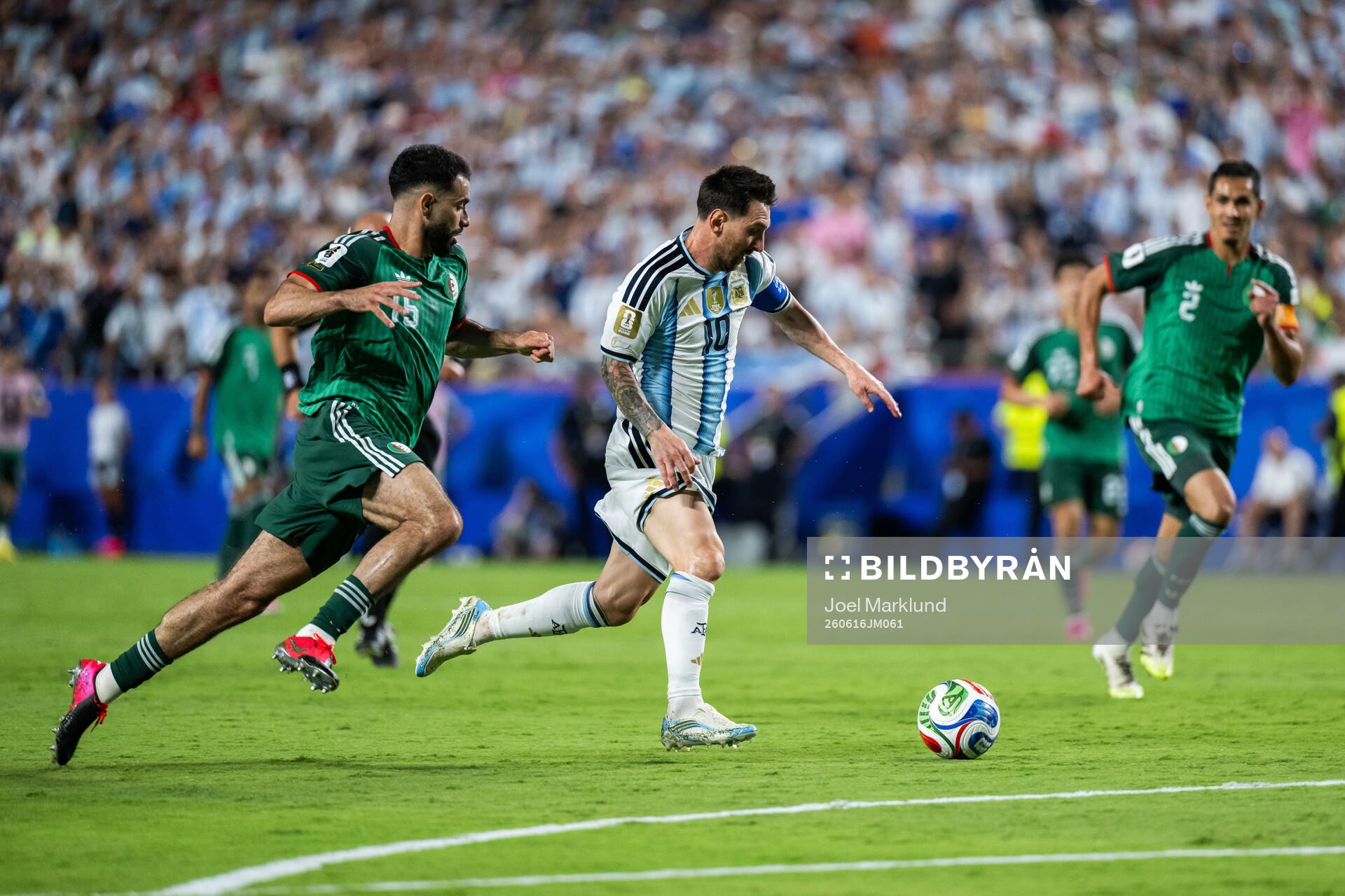 Rayan Ait-Nouri of Algeria and Lionel Messi of Argentina