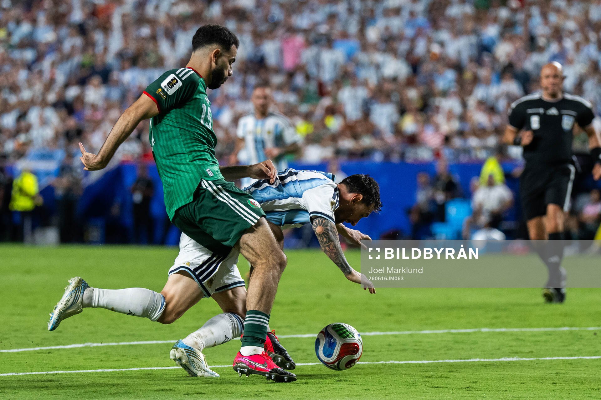 Rayan Ait-Nouri of Algeria and Lionel Messi of Argentina
