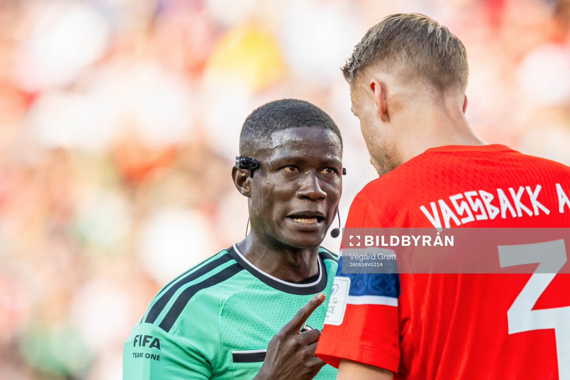 Referee Pierre Atcho talks to Kristoffer Ajer of Norway