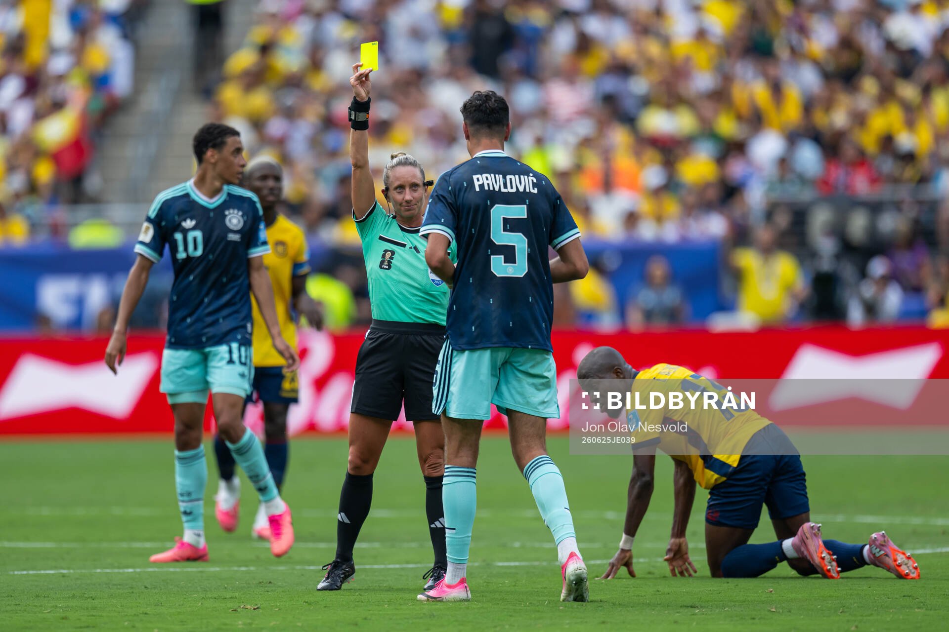 Aleksandar Pavlovic of Germany receives a yellow card from