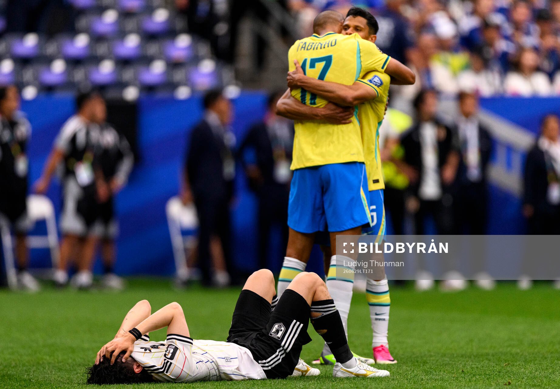 Fabinho of Brazil celebrates while a player of Japan looks
