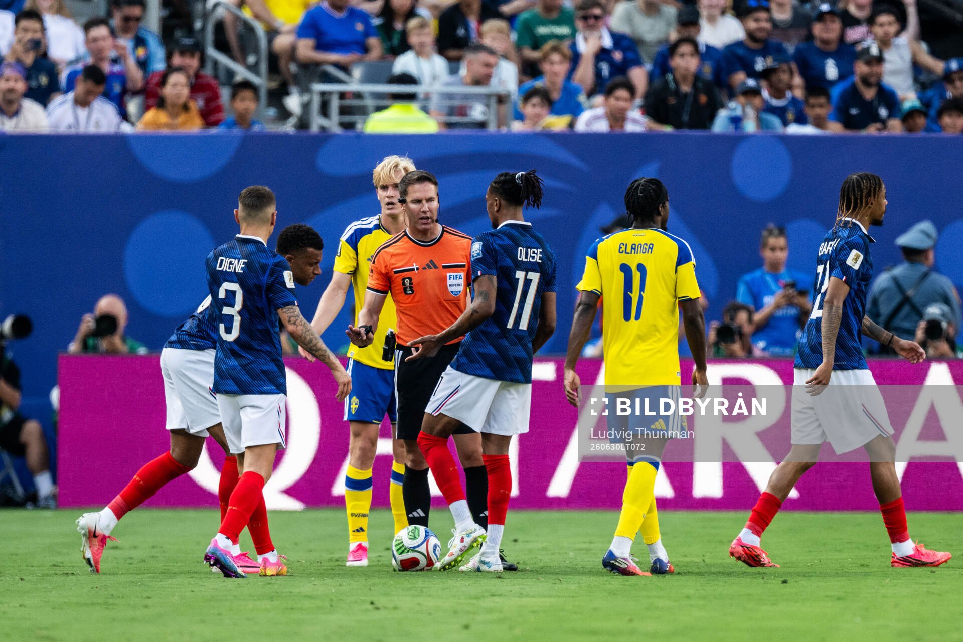 Referee Danny Makkelie with Michael Olise and Lucas Digne