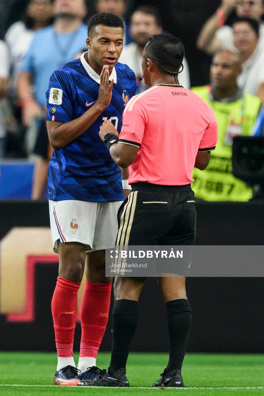 Kylian Mbappe of France and Referee Ivan Barton