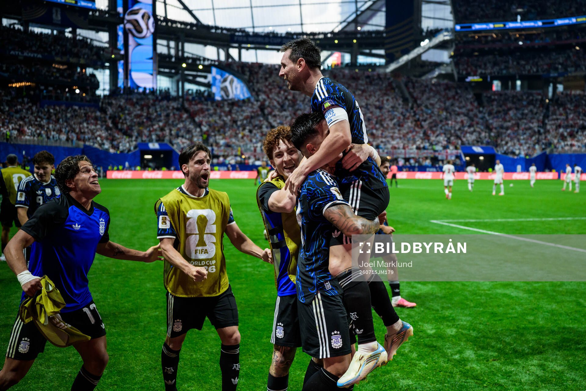 Enzo Fernandez hoists Lionel Messi of Argentina