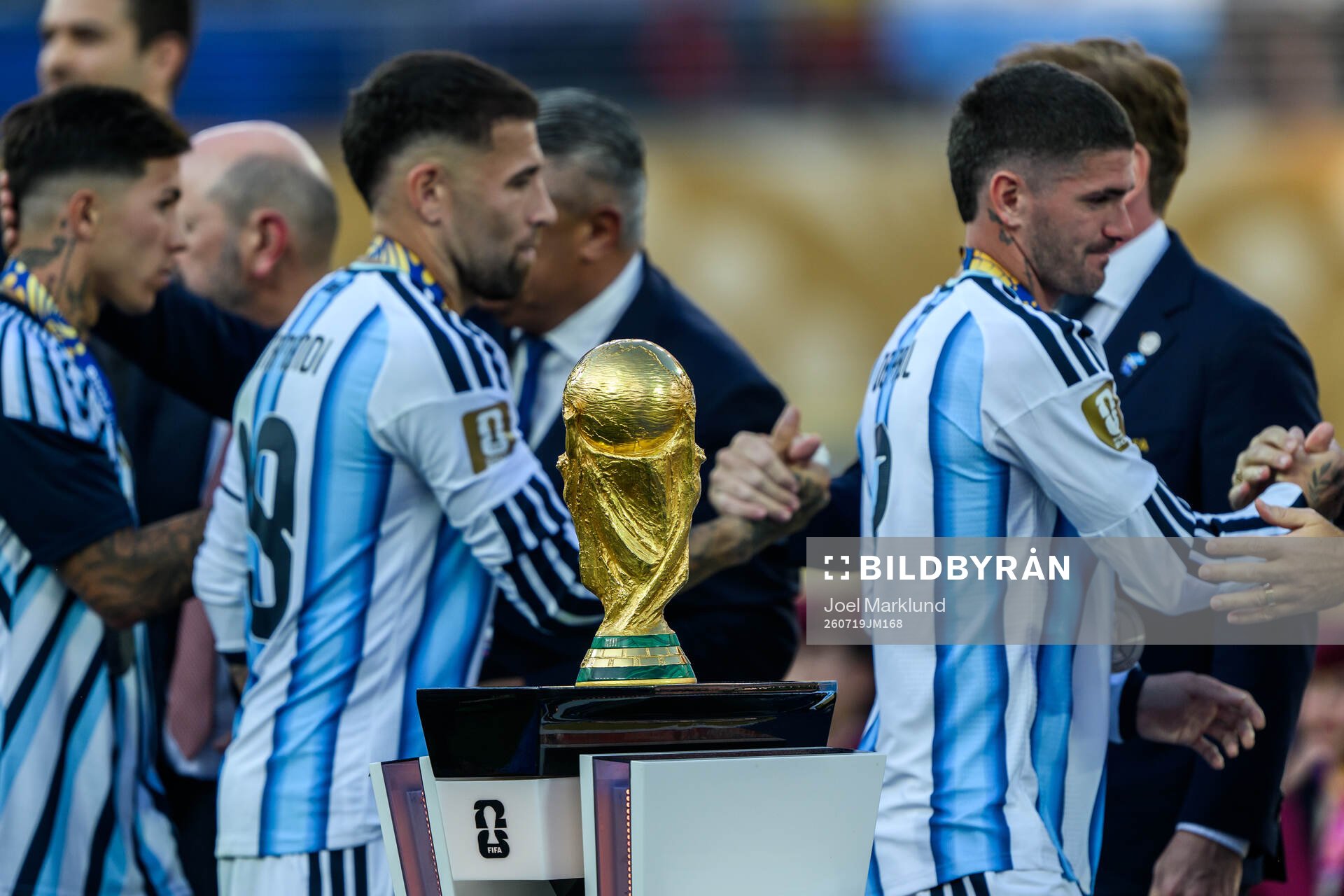 The trophy in front of Nicolas Otamendi and Rodrigo De Paul