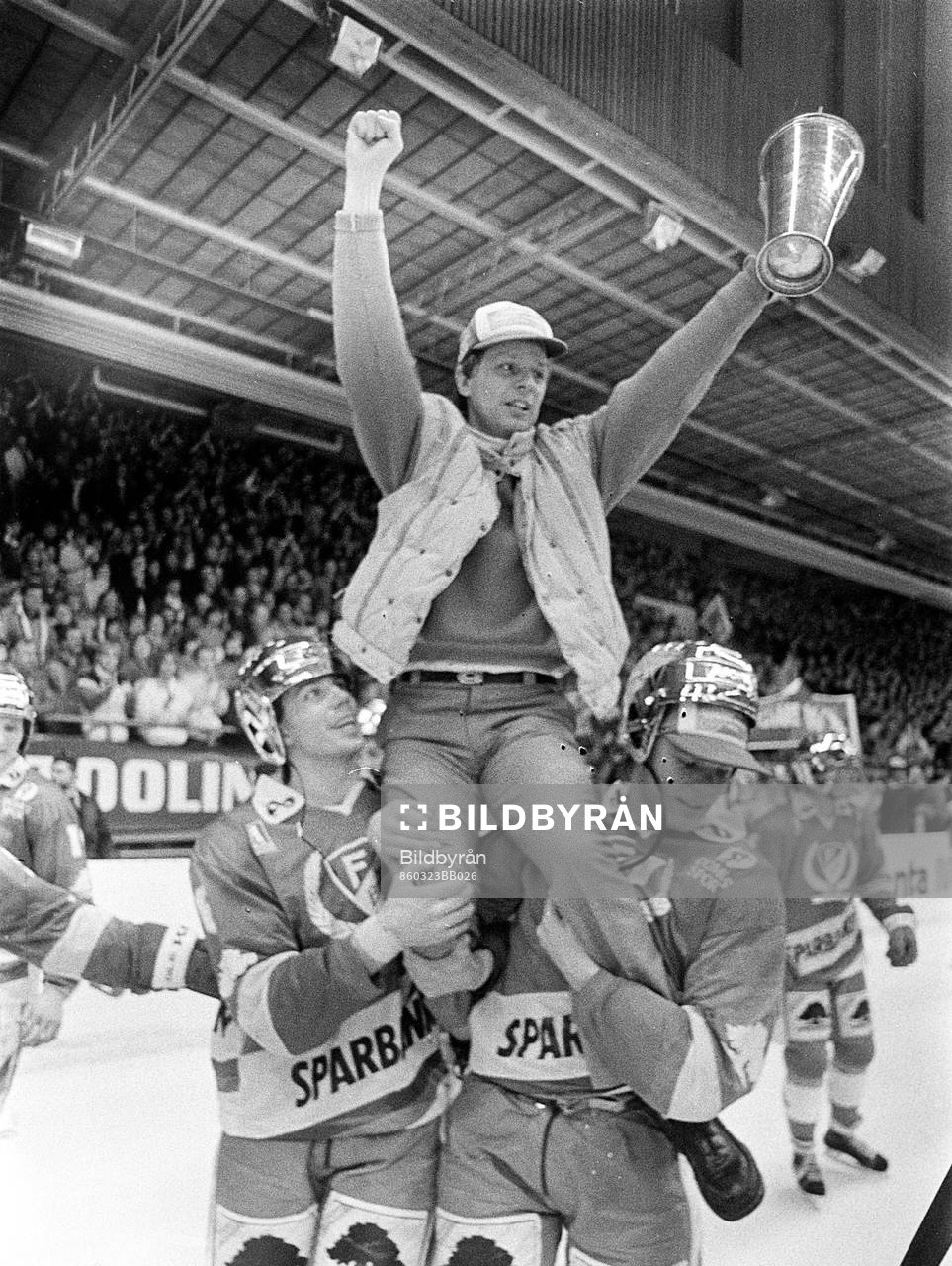 Conny Evensson, tränare i Färjestad på spelarnas axlar