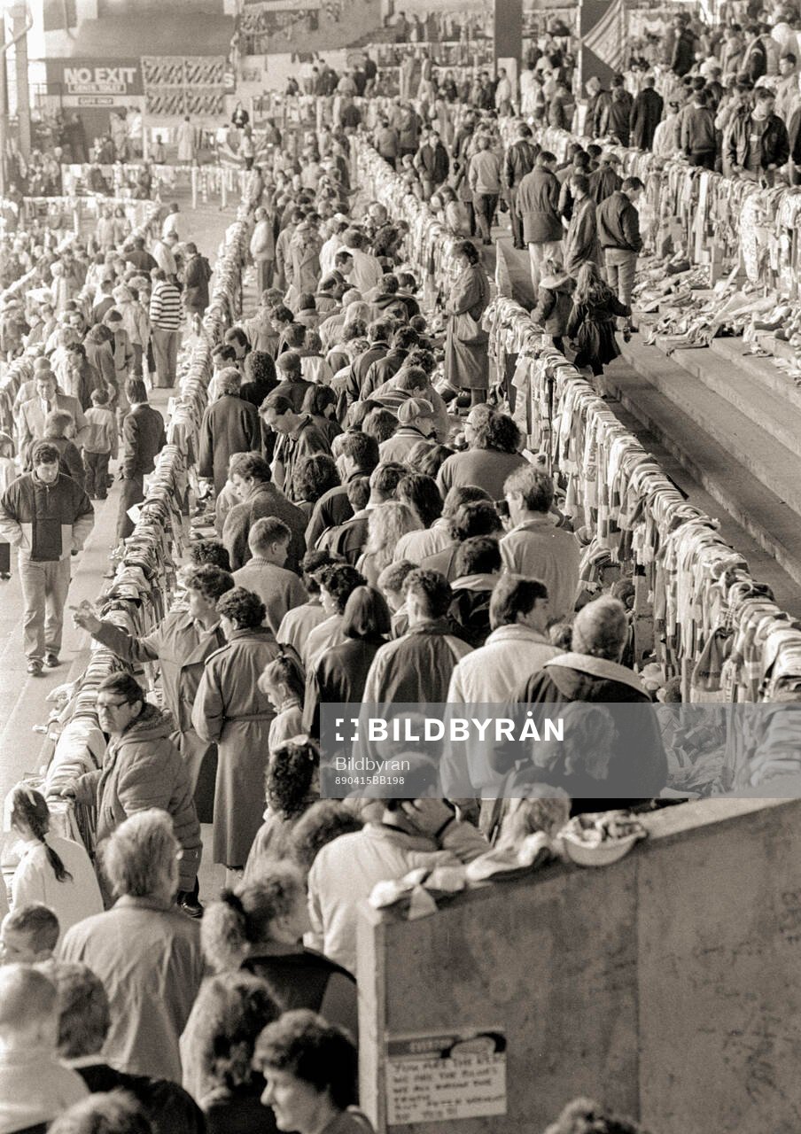 People look at a sea of flowers and scarves