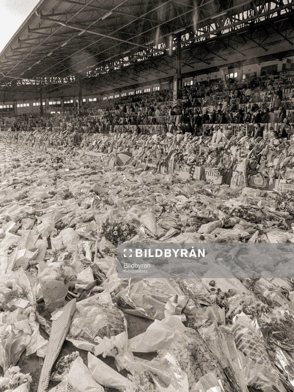 People look at a sea of flowers and scarves