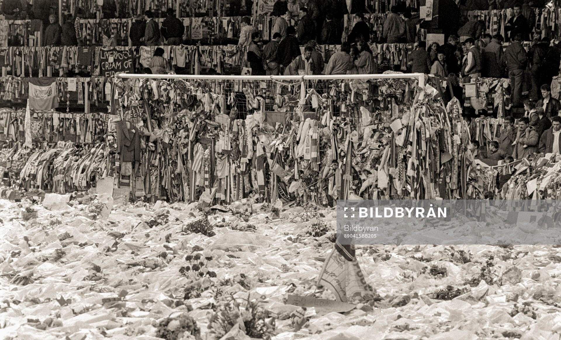 People look at a sea of flowers and scarves