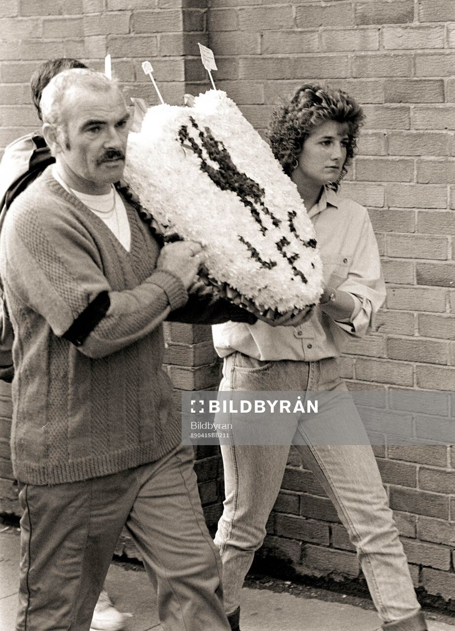 People with flowers outside Anfield to pay tribute to the
