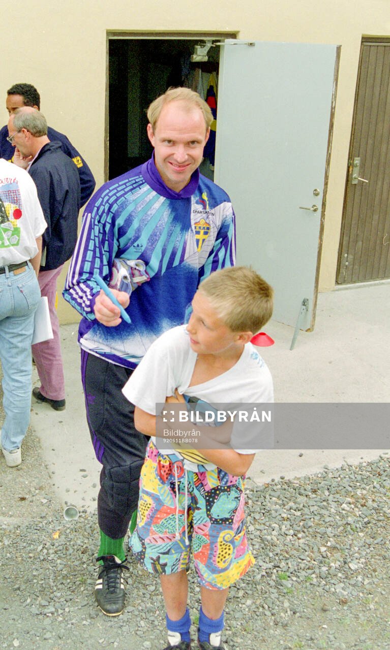 Swedens goalkeeper Thomas Ravelli writes autographs to