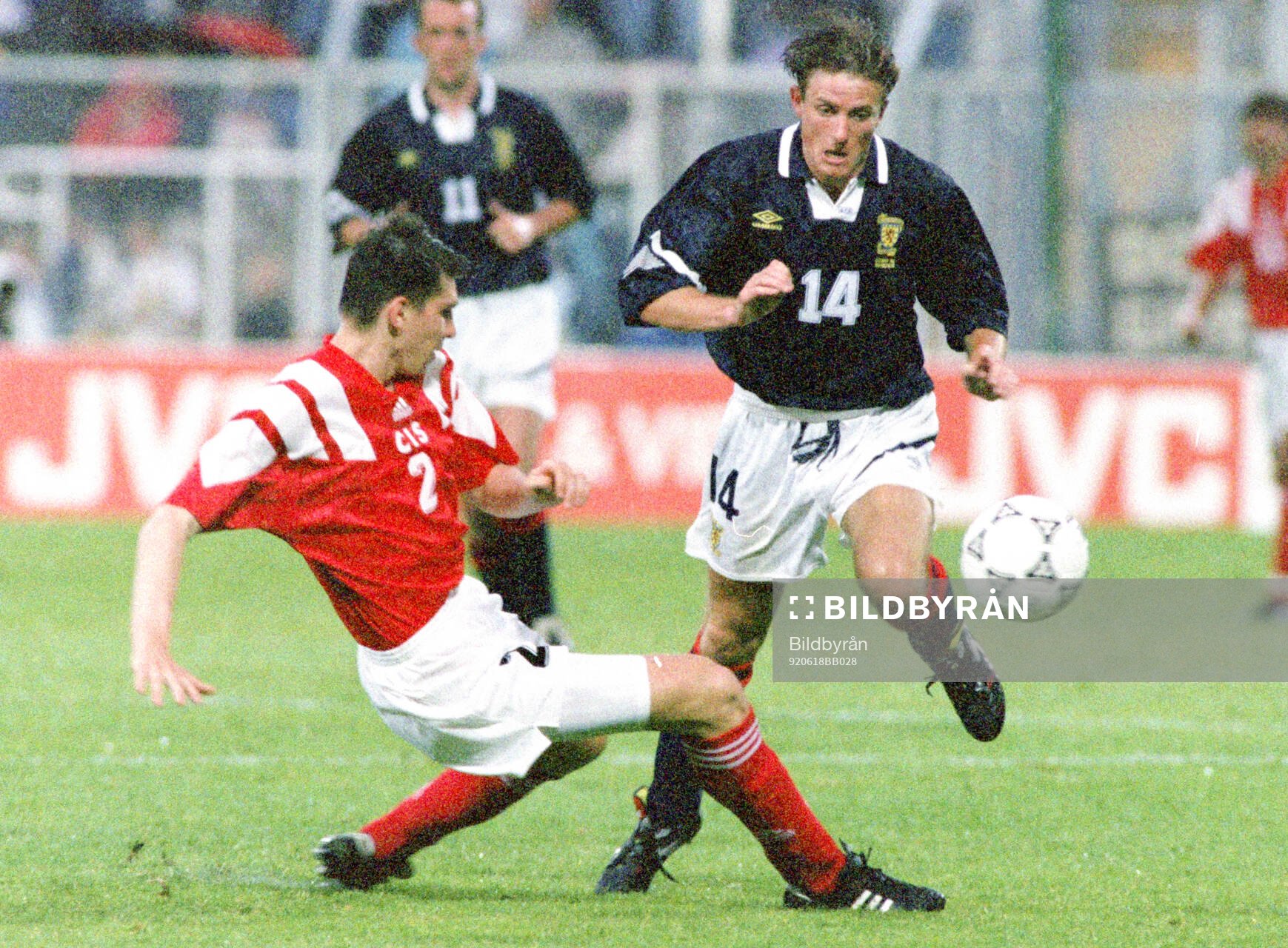 Andrey Chernyshov of CIS tackles Kevin Gallacher of Scotland