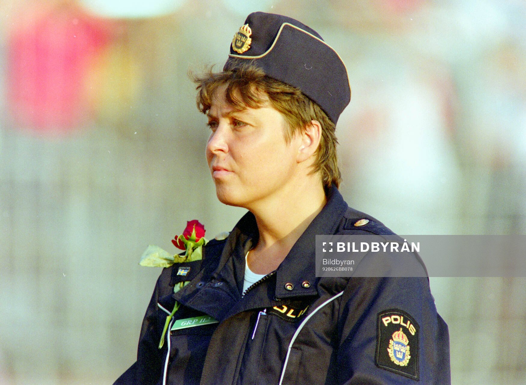 A swedish policewoman at the game with a flower she