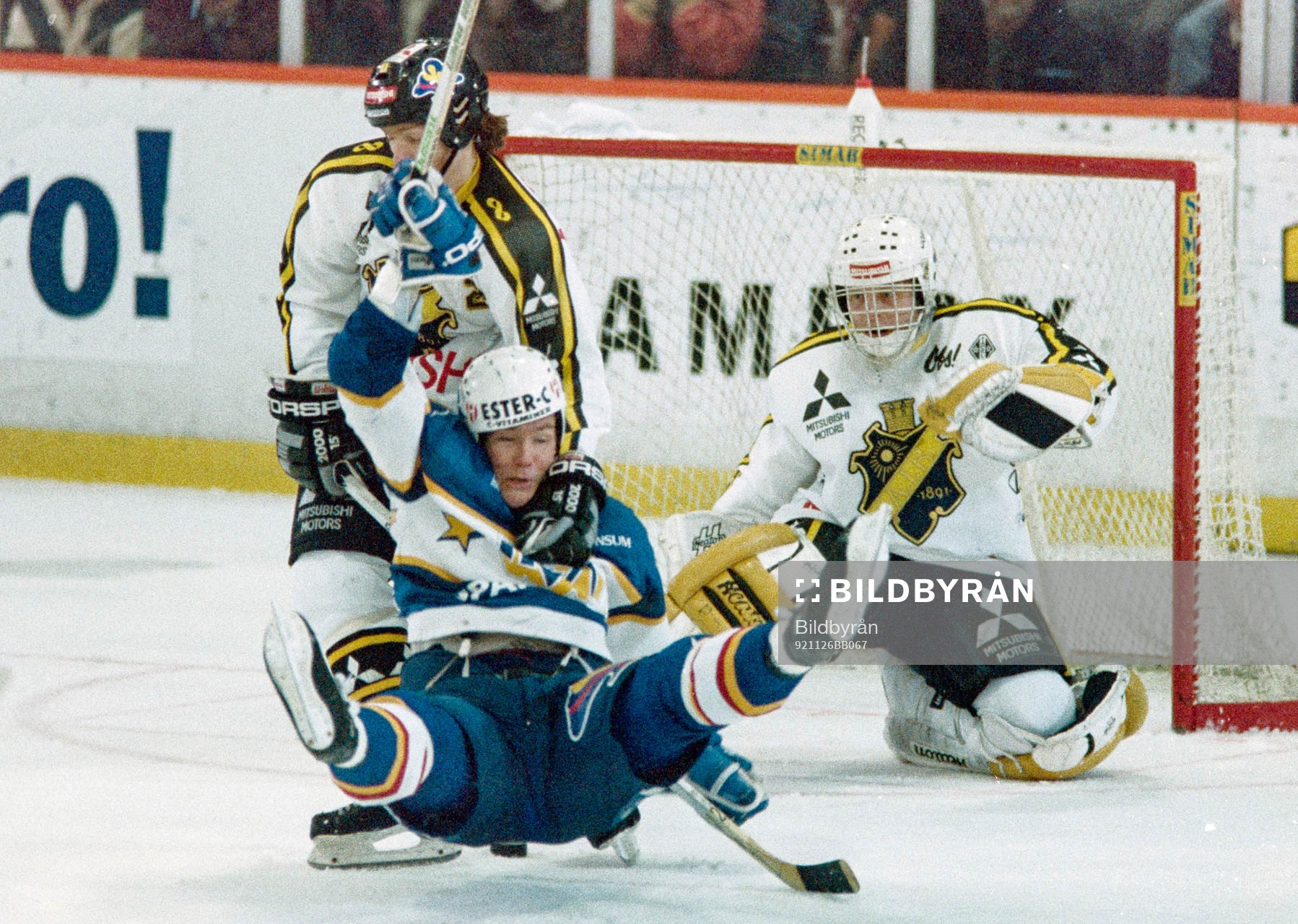 Peter Eriksson, HV71 dras omkull framför Rolf Ridderwall,