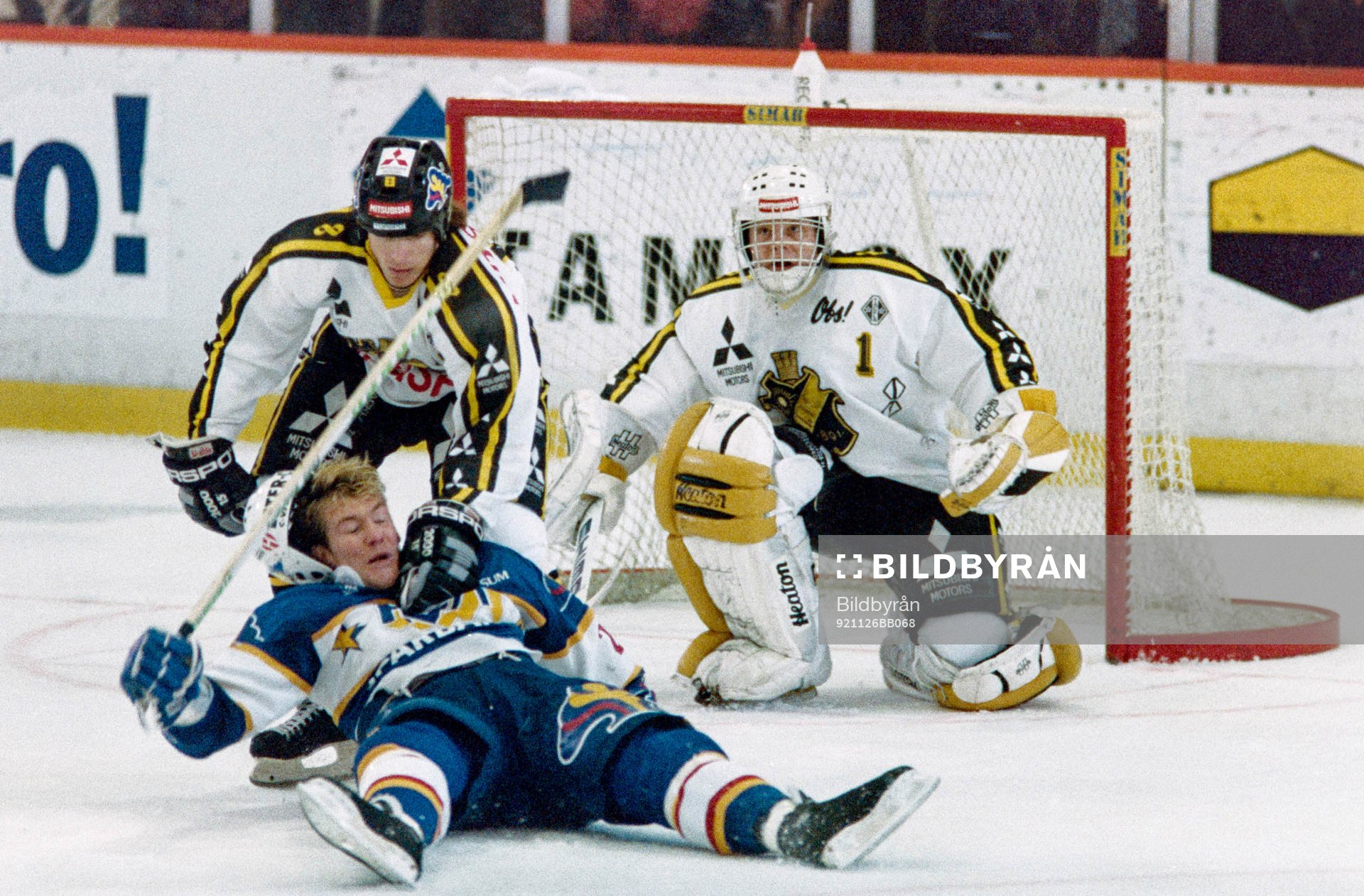 Peter Eriksson, HV71 dras omkull framför Rolf Ridderwall,