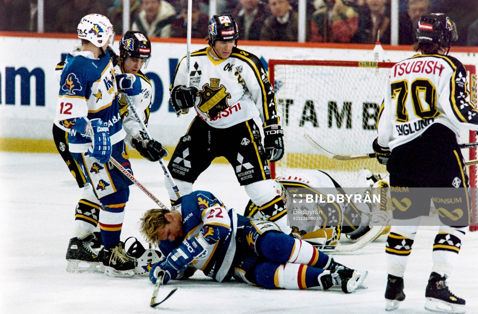 Peter Eriksson, HV71 dras omkull framför Rolf Ridderwall,