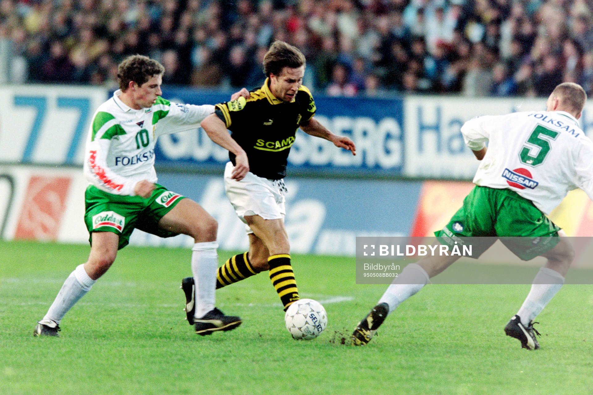Ola Andersson, AIK med bollen uppvaktas av Hans Bergh och