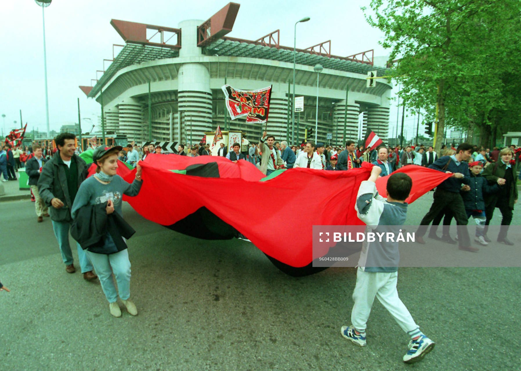 Milan-supportrar med flagga utanför Giuseppe Meazza -