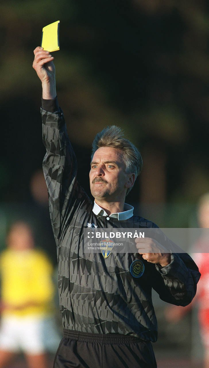 Domare Tony Rydén visar gult kort