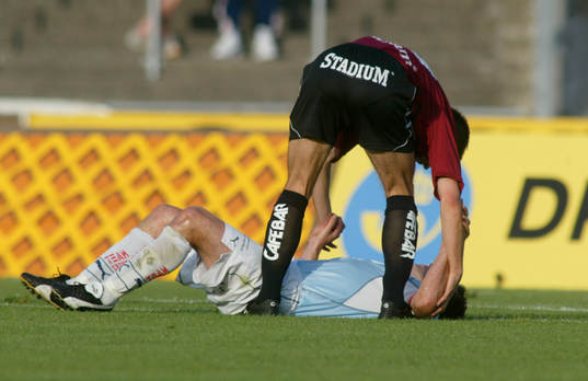 Skadad spelare hjälps av motståndare. Fair play