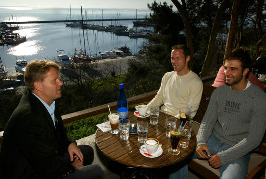  Fotboll, Grekisk, Svensk-kolonin Mats Jingblad, Magnus Källander och Kennedy Bakircioglu sitter på en uteservering vid hamnen i Thessaloniki