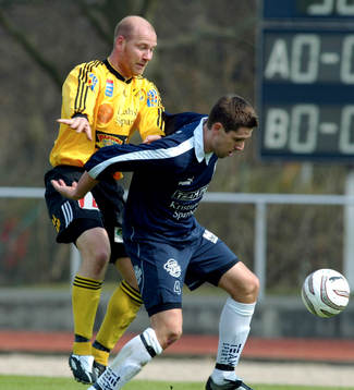 Mikael Thomasson trycks i ryggen av Peter Andersson