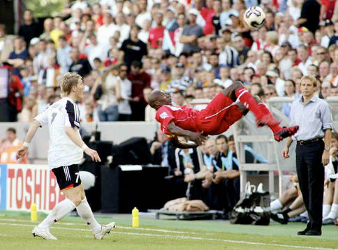   Hatem Trabelsi, Tunisien, i luften, Jurgen Klinsmann, förbundskapten, Tyskland ser på.