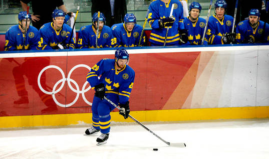 Henrik Sedin åker framför det svenska båset. Där sitter