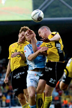 Jari Ilola och Andreas Augustsson trycker Emil Hallfredsson