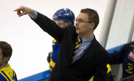 Johan Uhlin, förbundskapten, dirigerar från båset