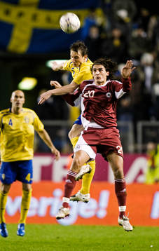 Kim Källström, Sverige, i kamp om bollen med Girts