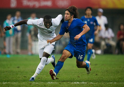  Takuya Honda, Japan, drar i tröjan på Jozy Altidore, USA.
