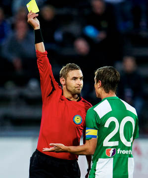 Jim Petersson, domare, delar ut ett gult kort till Filip