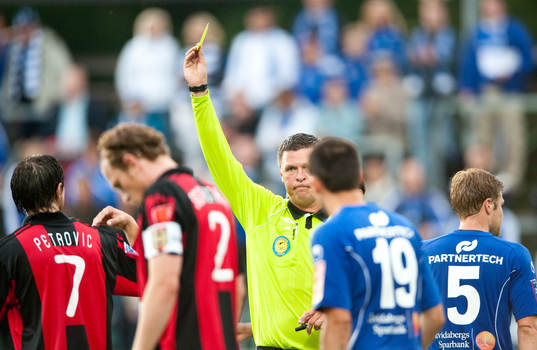 Domaren Antti Kanerva visar upp ett av många gula kort