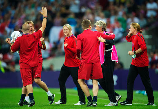 USA:s ledare, däribland Tony Gustavsson och Pia Sundhage, går in mot plan jublandes. Jubel.