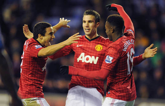  Football - Wigan Athletic v Manchester United - Barclays Premier League - DW Stadium - 1/1/13 Robin van Persie (C) celebrates scoring the fourth goal for Manchester United with Rafael da Silva and Danny Welbeck (R)