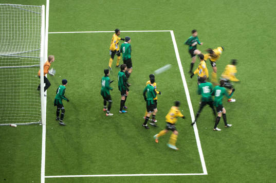 Spelare nickar bollen mot mål