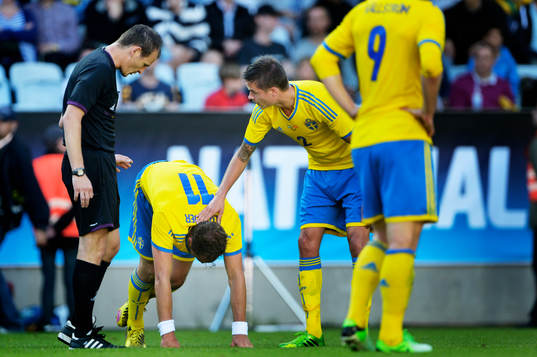 Johan Elmander får en klapp på axeln av Mikael Lustig