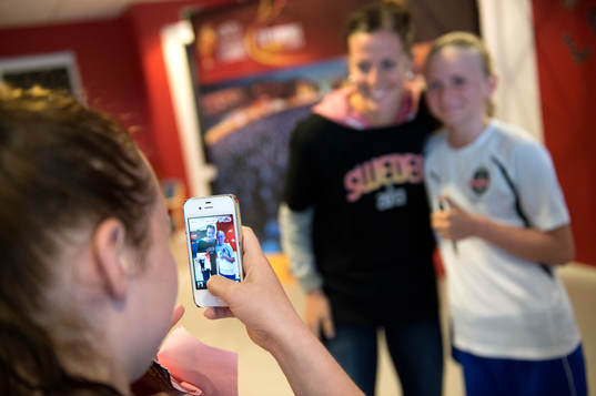  Lotta Schelin blir fotograferad med en av tjejerna.