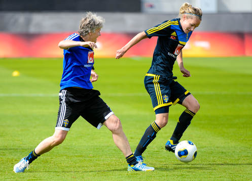 Sveriges förbundskapten Pia Sundhage i kamp om bollen med