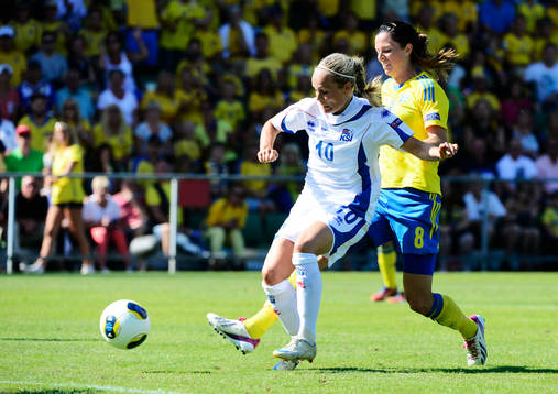 Sveriges Lotta Schelin dribblar bort Islands försvarare