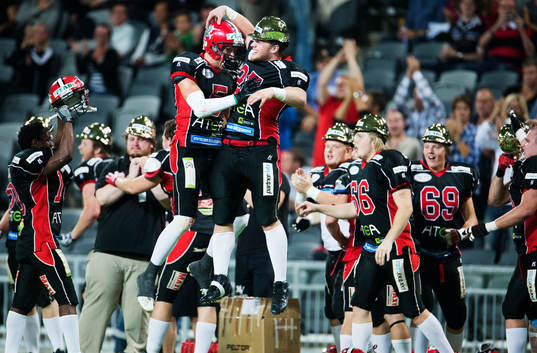 Carlstads Fredrik Isaksson och Brett Koepp jublar vid slutsignalen på SM-finalen i amerikansk fotboll mellan Carlstad Crusaders och Örebro Black Knights den 7 september 2013 i Stockholm.