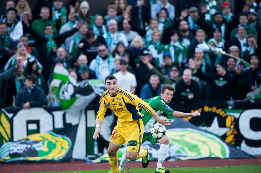 Ängelholms William Robert Warshaw och Hammarbys Nikolas Ledgerwood med Hammarbys supporters i ryggen i matchen i Superettan mellan Ängelholm och Hammarby 26 oktober 2013.