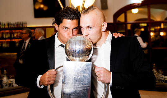 Miiko Albornoz och Magnus Eriksson kysser Lennart Johanssons pokal när de firar på guldbankett