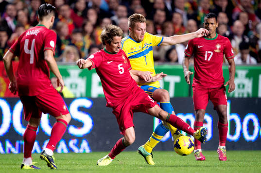 Sveriges Sebastian Larsson i kamp om bollen med Portugals