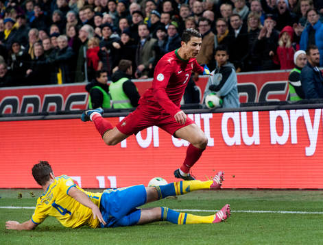 Sveriges Per Nilsson glidtacklar Portugals Cristiano Ronaldo i VM-kvalet mellan Sverige och Portugal i Stockholm 19 november 2013.