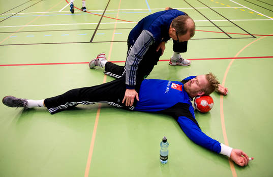 Målvakt Johan Sjöstrand får hjälp med stretching av