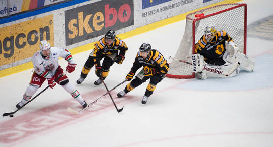 Modos Dave Spina jagas av Skellefteå-spelare i matchen i