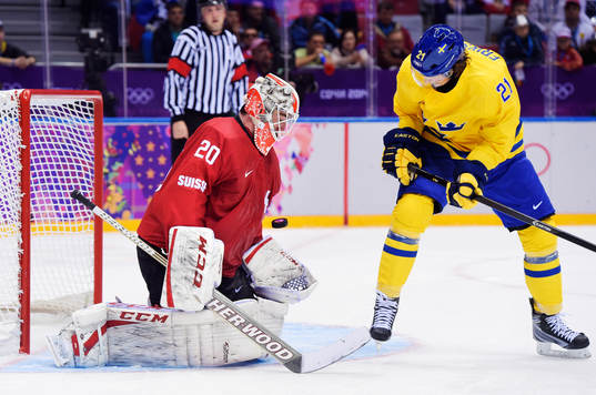 Schweiz målvakt Reto Berra räddar ett skott när Sveriges